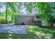Backyard view of the house, featuring a well-maintained yard, an elevated sunroom, and a back patio at 3938 Emerald Springs Ct, Decatur, GA 30035