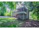 View of the house's rear, showing a spacious yard, a screened-in porch, and a back patio area at 3938 Emerald Springs Ct, Decatur, GA 30035