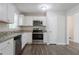 Open kitchen featuring stainless steel appliances, white cabinets, and granite countertops at 3938 Emerald Springs Ct, Decatur, GA 30035
