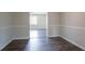 Bright living room with wood floors and white trim, featuring an open doorway to another room at 3938 Emerald Springs Ct, Decatur, GA 30035