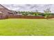 Well-maintained backyard with lush green grass, wood privacy fence, and young trees at 609 Turnbill Dr, Mcdonough, GA 30252
