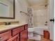 Well-lit bathroom featuring a vanity with sink, toilet, shower, and storage cabinet at 609 Turnbill Dr, Mcdonough, GA 30252