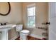 Cozy half bath with a pedestal sink, a decorative mirror, and a window at 609 Turnbill Dr, Mcdonough, GA 30252