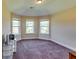 Bedroom featuring a carpeted floor, curved wall with three windows, and base trim at 609 Turnbill Dr, Mcdonough, GA 30252