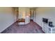Bedroom featuring carpet, table with lamps, television with shelving, and white trim at 609 Turnbill Dr, Mcdonough, GA 30252