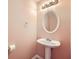 Well-lit half bath with a pedestal sink, mirror, and fresh paint at 982 Hunt Rd, Jonesboro, GA 30236