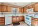 Traditional kitchen featuring wood cabinets, white appliances, tile backsplash, and a stainless steel sink at 982 Hunt Rd, Jonesboro, GA 30236