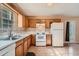Bright kitchen featuring tile floors, wood cabinets, white appliances, and access to the outdoors at 982 Hunt Rd, Jonesboro, GA 30236