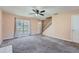 Inviting living room features neutral walls, plush carpet, stairs, and lots of natural light at 982 Hunt Rd, Jonesboro, GA 30236