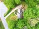 Aerial view of a house surrounded by mature trees, a driveway, and lush greenery, showcasing its private setting at 1864 Gloucester Ct, Snellville, GA 30078