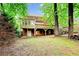 Expansive backyard featuring mature trees, a wooden deck, and walkout basement access to the lush surroundings at 1864 Gloucester Ct, Snellville, GA 30078