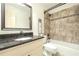 Well-lit bathroom with granite countertop vanity and tiled shower-tub combination at 1864 Gloucester Ct, Snellville, GA 30078