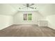 Spacious bonus room features neutral carpet, ceiling fan, and a window allowing natural light to fill the space at 1864 Gloucester Ct, Snellville, GA 30078