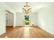 Formal dining room with hardwood floors, classic chandelier, and bright window at 1864 Gloucester Ct, Snellville, GA 30078