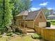 Back exterior showcasing a brick home, wooden deck, lush backyard, and charming landscaping at 1864 Gloucester Ct, Snellville, GA 30078