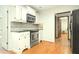 Bright kitchen featuring stainless steel appliances, white cabinets, and hardwood floors at 1864 Gloucester Ct, Snellville, GA 30078