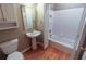 Bright bathroom featuring hardwood floors, toilet, sink, mirror, and tile bath with shower at 4055 Vista Point Ln, Suwanee, GA 30024
