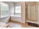 Bright bathroom boasts a soaking tub beneath a window and a glass shower at 5601 Savannah River Rd, Atlanta, GA 30349