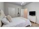 Clean bedroom featuring soft white bedding, modern light fixture, and multiple doors and storage options at 5601 Savannah River Rd, Atlanta, GA 30349