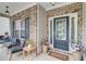 Inviting front porch with seating area, brick accents, and decorative potted plants near the front door at 5601 Savannah River Rd, Atlanta, GA 30349