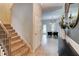 Hallway leads to open concept dining area, featuring neutral paint colors, hardwood floors and staircase at 5601 Savannah River Rd, Atlanta, GA 30349