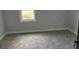 Bedroom with neutral carpeting, gray paint and a new window at 6774 Collier Rd, Riverdale, GA 30296