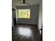 A bedroom featuring a dark ceiling fan, wood look floors, and large window at 6774 Collier Rd, Riverdale, GA 30296