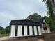 Newly renovated home with black accents, a new roof, and an A-frame design with a balcony at 6774 Collier Rd, Riverdale, GA 30296