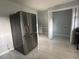 Modern stainless steel refrigerator in a kitchen with marble floors and an open doorway to another room at 6774 Collier Rd, Riverdale, GA 30296