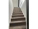 Carpeted stairway featuring neutral tones and natural light at 6774 Collier Rd, Riverdale, GA 30296