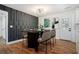 Dining room features a modern light fixture, dark accent wall, and sleek table seating for six at 904 Fairburn Nw Pl, Atlanta, GA 30331