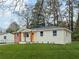 Newly renovated single story home featuring a well maintained lawn and orange front door at 904 Fairburn Nw Pl, Atlanta, GA 30331