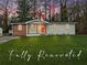 Renovated single-story house with a lush green lawn, orange front door, and wooden columns at 904 Fairburn Nw Pl, Atlanta, GA 30331