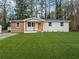 Charming renovated single-story home featuring a well-manicured lawn and an inviting orange front door at 904 Fairburn Nw Pl, Atlanta, GA 30331