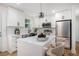 Bright kitchen features white cabinetry, stainless appliances, island with counter seating, and stylish pendant lighting at 904 Fairburn Nw Pl, Atlanta, GA 30331