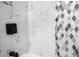 A close-up of white marble wall tile with decorative mosaic detail in the shower at 904 Fairburn Nw Pl, Atlanta, GA 30331