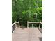 A wooden deck offers a view of the private, wooded backyard at 211 Buckland Dr, Alpharetta, GA 30022