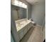 Bathroom featuring double sinks, tile floors, a large mirror, and a shower and tub combo at 211 Buckland Dr, Alpharetta, GA 30022