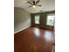 Bright bedroom featuring a ceiling fan, hardwood floors, and lots of natural light from large windows at 211 Buckland Dr, Alpharetta, GA 30022