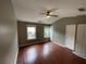 A cozy bedroom with hardwood floors, natural light from two windows, and a ceiling fan at 211 Buckland Dr, Alpharetta, GA 30022