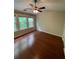 Bright bedroom featuring a ceiling fan, hardwood floors, and lots of natural light from large windows at 211 Buckland Dr, Alpharetta, GA 30022