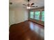Bright bedroom featuring a ceiling fan, hardwood floors, and lots of natural light from large windows at 211 Buckland Dr, Alpharetta, GA 30022