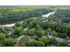 Aerial view of a neighborhood nestled among lush trees and a tranquil lake, showcasing natural beauty at 448 Teal Ct, Roswell, GA 30076