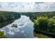 Scenic aerial shot of a calm lake reflecting the sky and surrounded by dense green trees at 448 Teal Ct, Roswell, GA 30076