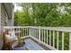 A cozy balcony featuring a wood bench, a blue rug, and a scenic view of lush green trees at 448 Teal Ct, Roswell, GA 30076