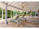 Covered back patio featuring stone flooring, ceiling fans, and outdoor seating at 5070 Riverlake Dr, Peachtree Corners, GA 30097