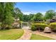 Scenic backyard view featuring a swing by the lake and lush landscaping at 5070 Riverlake Dr, Peachtree Corners, GA 30097