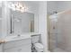 A well-lit bathroom with a shower and sink with white tile and gold trim at 5070 Riverlake Dr, Peachtree Corners, GA 30097