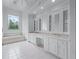 Bright bathroom with a double vanity, ample storage, tiled floors, and a garden tub near a stained glass window at 5070 Riverlake Dr, Peachtree Corners, GA 30097