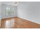 Bright bedroom boasts wood floors, ceiling fan, and shuttered window at 5070 Riverlake Dr, Peachtree Corners, GA 30097